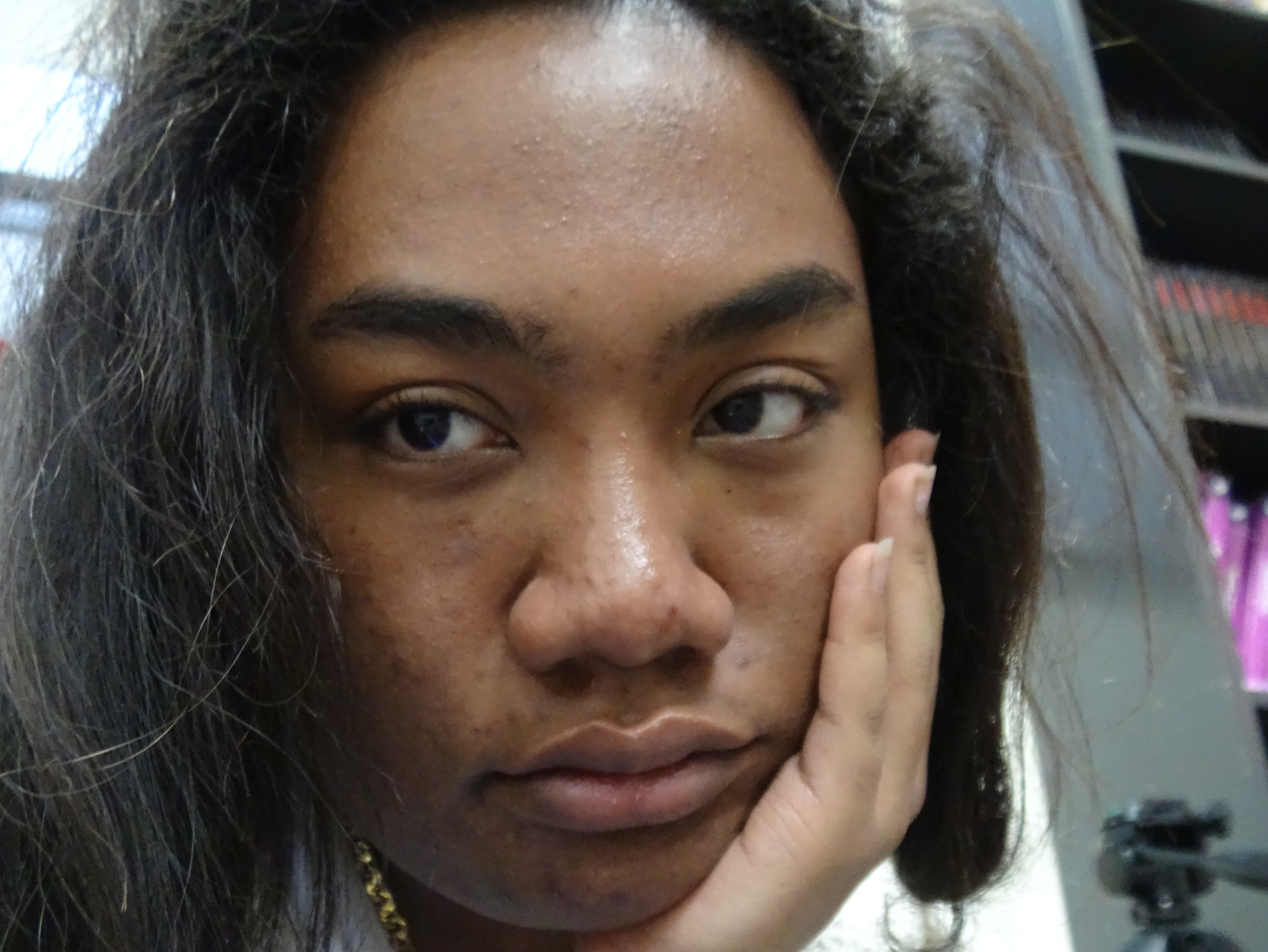 influencer and model elidae danh whipping her hair up while head is slightly down while sitting up